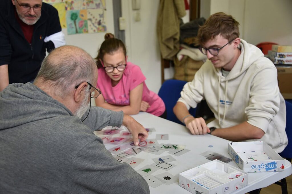 Un grand-père joue avec ses petits-enfants à un jeu de société.