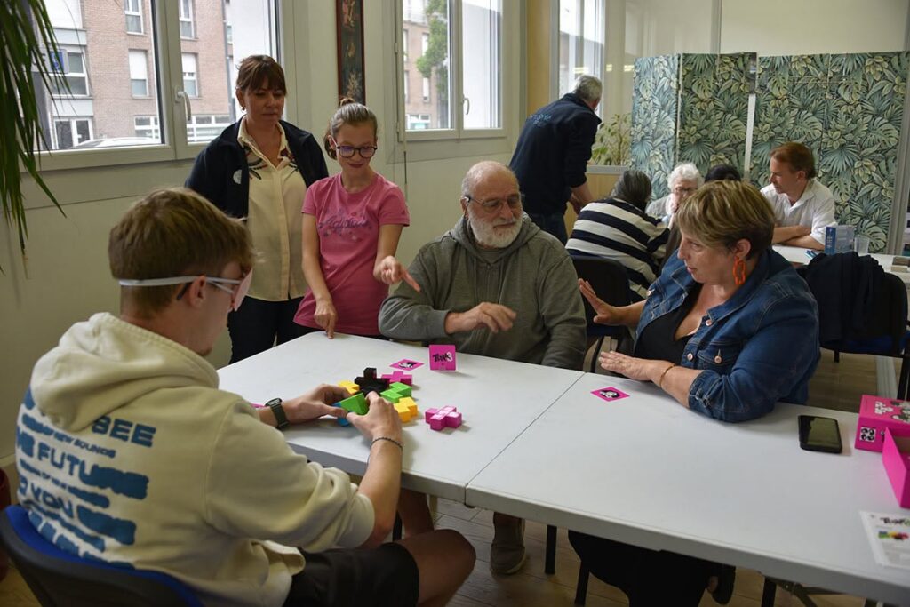 Une professionnelle de SimUSanté accompagne une famille pendant une session de jeu de société.