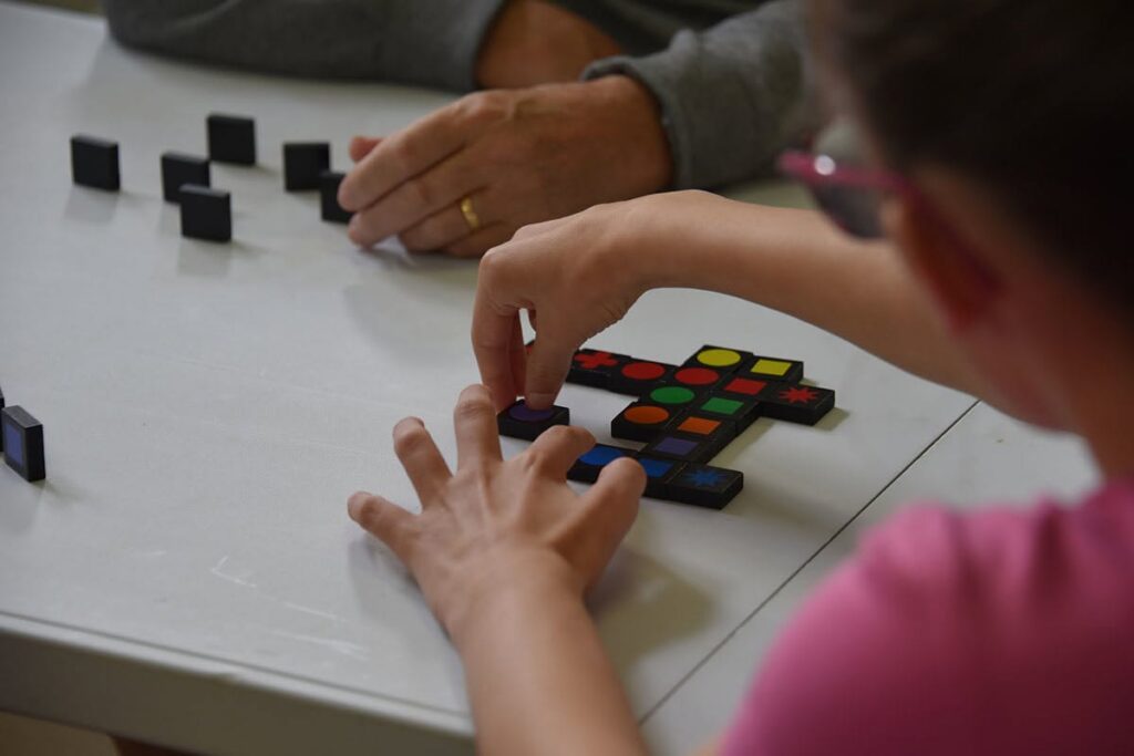 Une petite fille assemble des dominos.